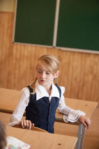 Full length of girl sitting on table