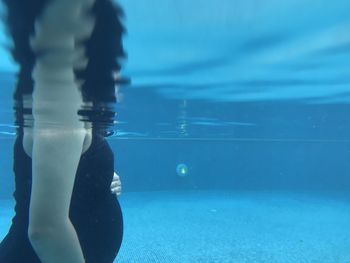 Low section of person swimming in pool