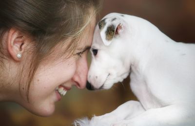 Close-up of smiling woman playing with dog