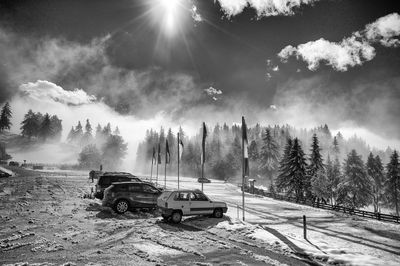 Cars on snow field against sky