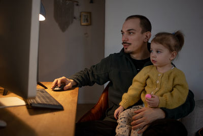 Father with daughter using desktop pc at home