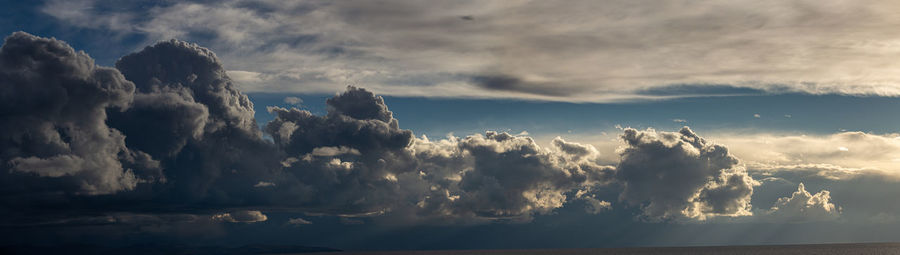 Low angle view of sunlight streaming through clouds
