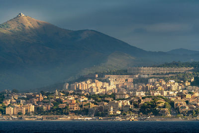 City by sea against cloudy sky