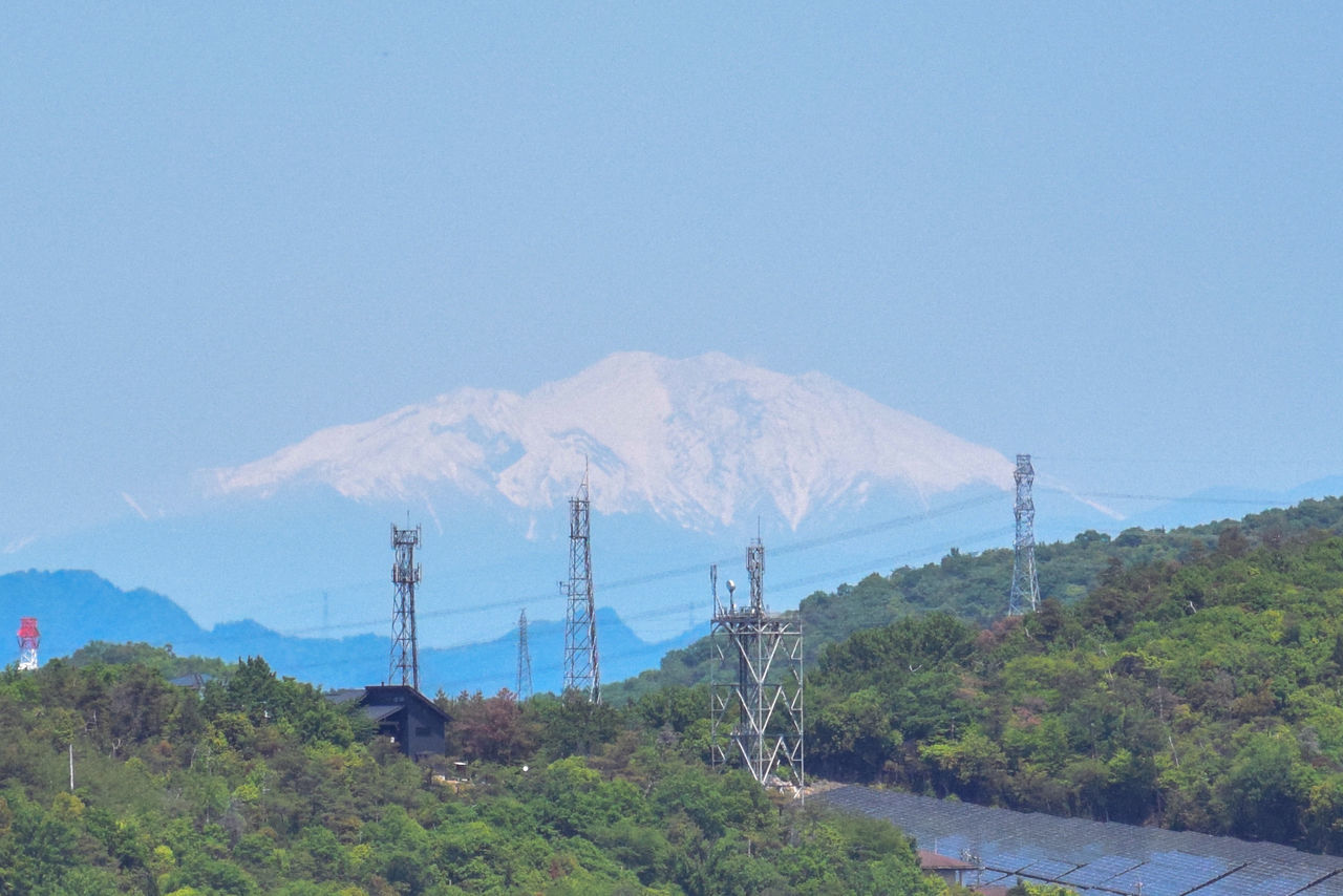 mountain, sky, scenics - nature, nature, beauty in nature, environment, landscape, no people, land, plant, tree, mountain range, day, non-urban scene, travel destinations, blue, outdoors, clear sky, technology, tranquility, tranquil scene, volcano, travel, electricity, ridge, mountain peak