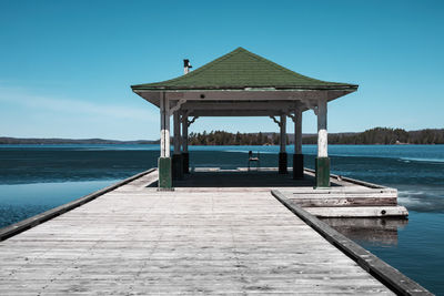 A photograph of a old government dock taken on a sunny warm day during the spring thaw
