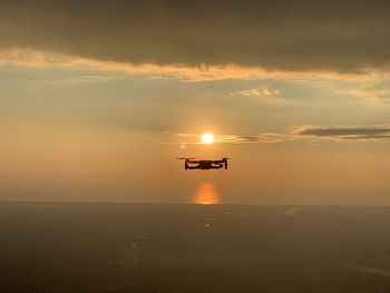 Silhouette boat in sea against sky during sunset