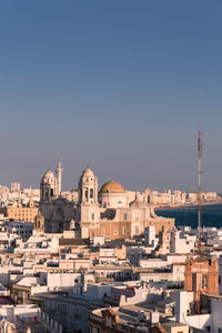 Buildings in city against clear sky