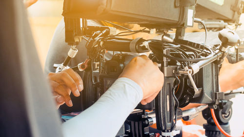 Cropped hands operating television camera