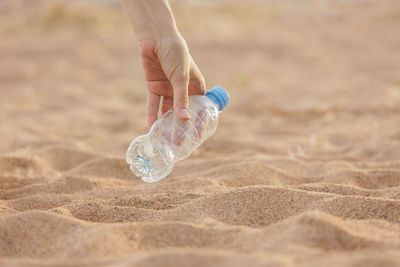 Close-up of water bottle at beach