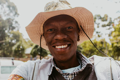 Portrait of smiling man wearing hat outdoors