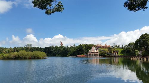 Scenic view of river by trees against sky