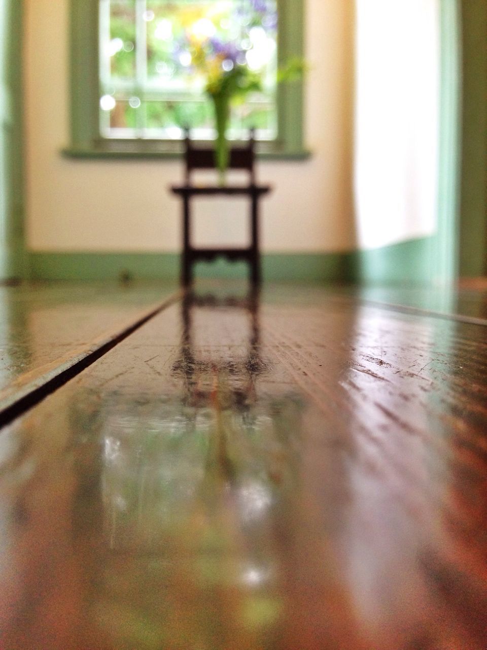 indoors, window, table, selective focus, glass - material, reflection, transparent, built structure, architecture, focus on foreground, water, wood - material, flooring, home interior, surface level, no people, day, empty, close-up, house