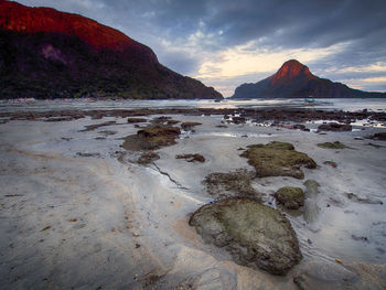 Scenic view of beach against cloudy sky