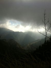 Scenic view of mountains against cloudy sky