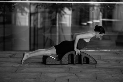 Side view of woman sitting on floor