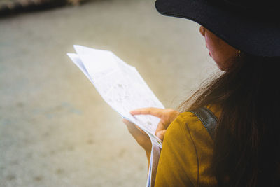 Portrait of woman holding paper outdoors