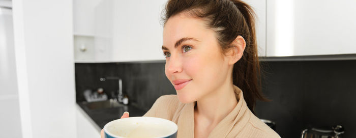 Young woman drinking coffee at home