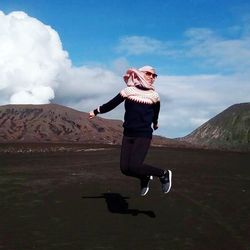 Full length of a man skateboarding on mountain against sky