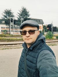 Portrait of young man wearing sunglasses standing outdoors