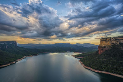 Scenic view of mountain against cloudy sky during sunset