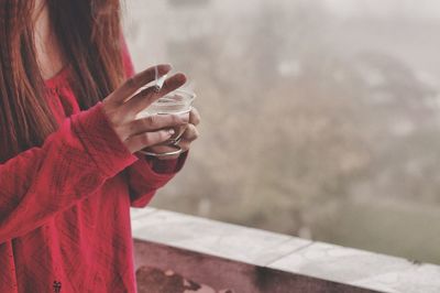 Midsection of woman holding coffee cup and cigarette