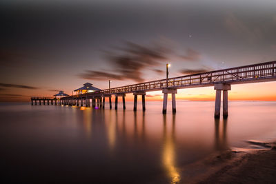 Bridge over sea against sky during sunset