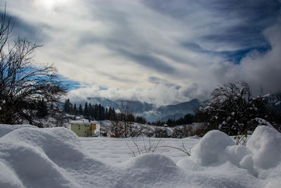 Scenic view of snow covered field against sky