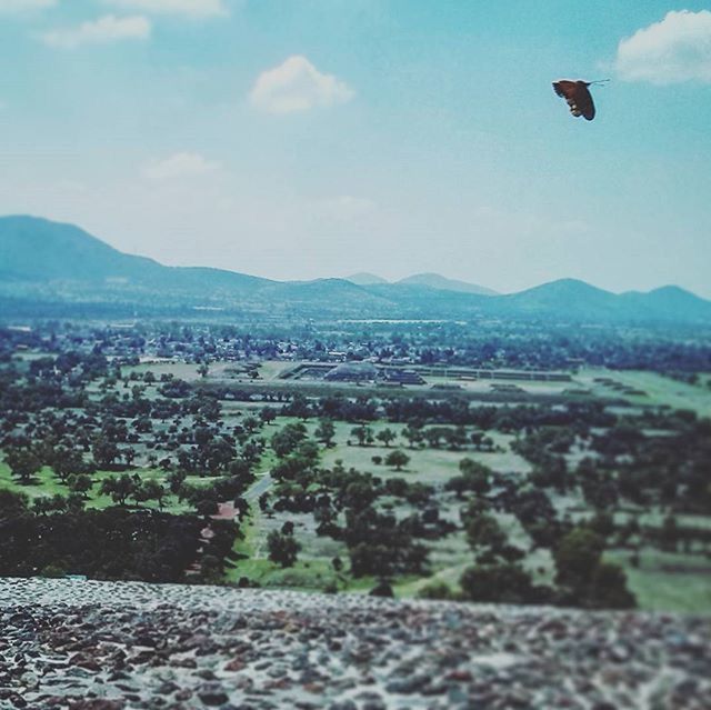 mountain, sky, landscape, mountain range, flying, building exterior, built structure, scenics, nature, high angle view, cityscape, architecture, day, beauty in nature, outdoors, blue, tranquil scene, city, cloud - sky, transportation