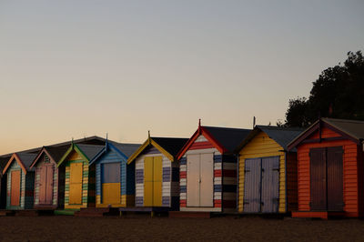 Row of houses on beach against clear sky