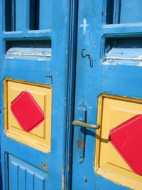 Close-up of yellow mailbox on blue door