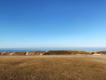 Scenic view of field against clear blue sky