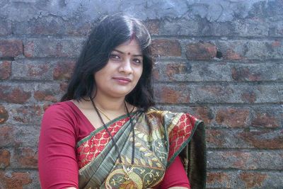 Portrait of woman standing against wall