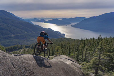 Rear view of man riding bicycle on mountain