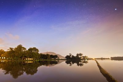 Scenic view of lake against sky at night