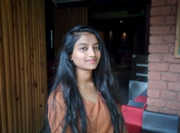 Portrait of young woman with long hair at home