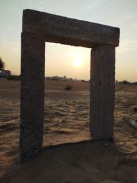 Old ruin on field against sky during sunset