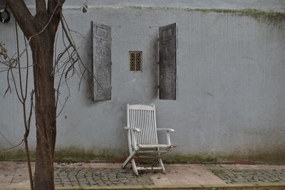 Empty chairs and tables against wall