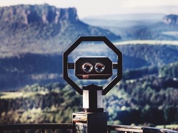 Close-up of coin-operated binoculars against sky