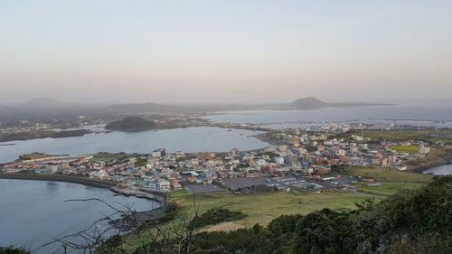 Cityscape by sea against sky