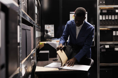 Side view of man standing in factory