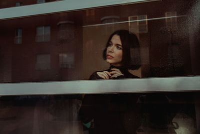 Portrait of a woman looking through window