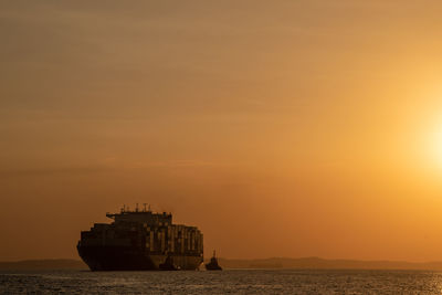 Boat in sea against sky during sunset