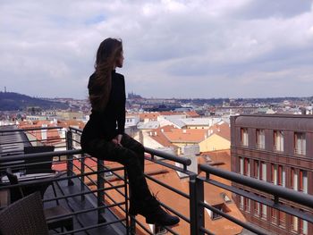 Woman in balcony looking at cityscape