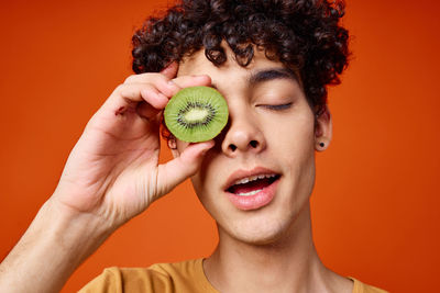 Close-up of man holding kiwi