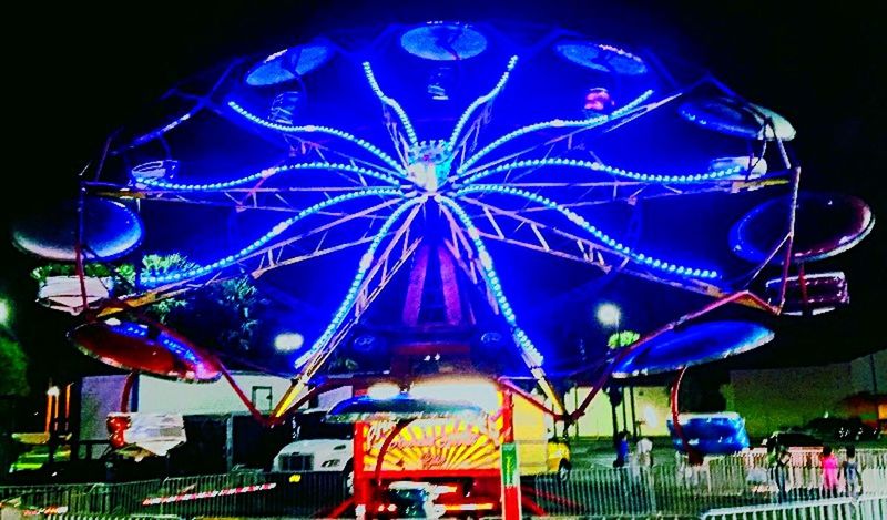 ILLUMINATED FERRIS WHEEL AGAINST BLUE SKY