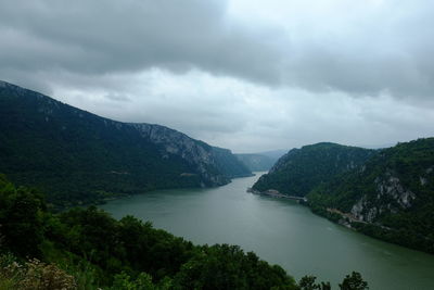 Scenic view of river amidst mountains against sky