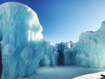 Panoramic view of frozen landscape against clear blue sky