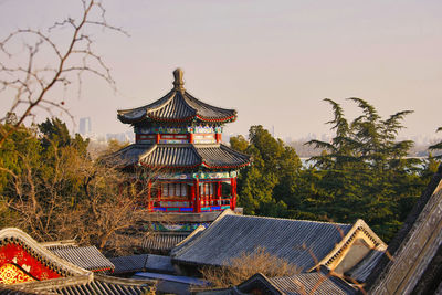 Temple by building against sky