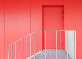 Empty corridor of building withe a red dor. 