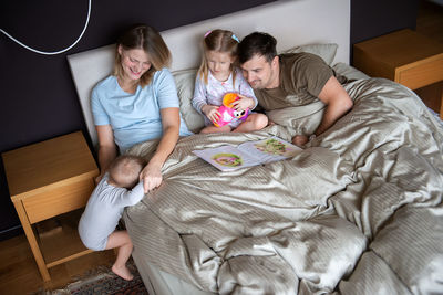 High angle view of parents with children on bed at home